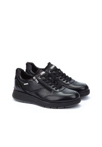 Zapatillas negras de cuero con una textura suave, que cuentan con cierre de cordones y cremallera, cuello acolchado y suela de goma para mayor comodidad.