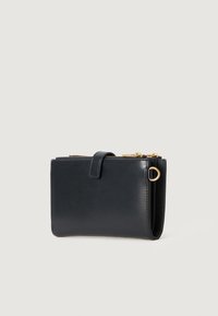 Carteira de couro preto com uma textura suave, fecho em zip, um detalhe em laço e um design retangular esbelto. Apresenta um fecho seguro.
