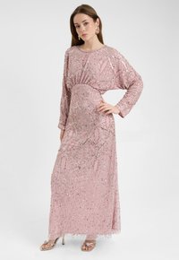 Roze pailletten lange jurk met lange mouwen, versierd met een bloemenpatroon en een geraffineerde taille. Gecombineerd met metallic hakken.