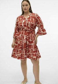 Abito a scacchi rosso e crema con orlo svasato, maniche lunghe e vita cintrata. Realizzato in un tessuto morbido con un design geometrico.