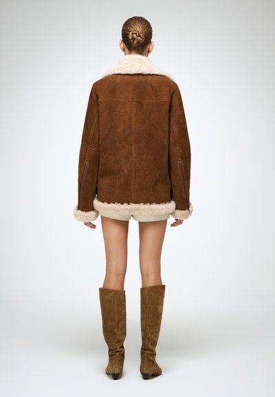 Braune Wildlederjacke mit einem weichen, cremefarbenen Lammfellkragen und -manschetten. Das Design zeichnet sich durch eine lockere Passform und Reißverschlusstaschen aus.