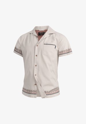 Chemise à manches courtes avec boutons en beige clair, en tissu texturé, poche poitrine et motifs décoratifs sur les manches et l'ourlet.