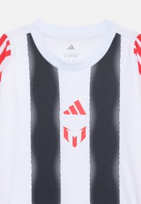 Short-sleeve white sports jersey featuring black vertical stripes, red accents on sleeves, and a distinctive logo in the center.