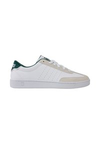 Baskets blanches avec bout en daim, accents verts sur le talon et la languette, dessus texturé avec perforations, et lacets blancs.