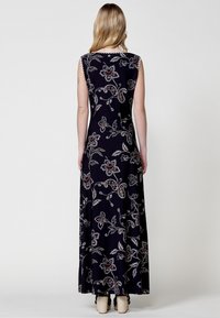 Robe maxi en tissu bleu marine foncé, ornée d'un imprimé floral avec des accents rouges et argentés, sans manches, et une silhouette fluide.