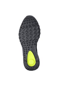 Zwarte rubberen schoenenzool met gestructureerde, cirkelvormige patronen en een opvallend groen accent bij de hiel, voorzien van merkdetails voor duurzaamheid.