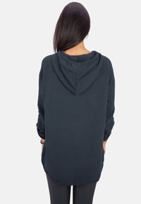 Dunkelgrauer Hoodie aus strukturiertem Stoff, mit Kapuze, langen Ärmeln und lockerer Passform mit abgerundetem Saum.