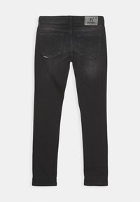 Zwarte denim jeans met een vijf-pocket ontwerp, slim fit en subtiele branding op de achterzak en tailleband. Soepele textuur.