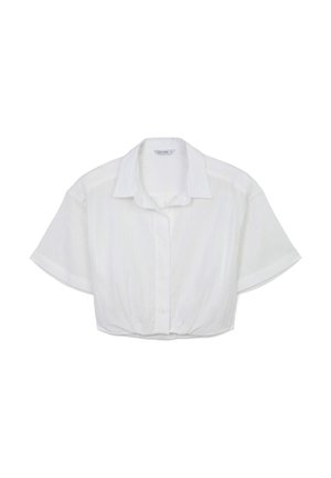 Chemise blanche courte à manches courtes, avec un tissu texturé et un ourlet arrondi. Design simple, sans accents supplémentaires.