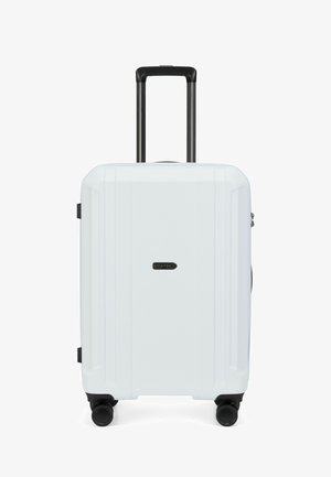 Valise rigide blanche avec quatre roues noires pivotantes et une poignée télescopique noire dépliée.