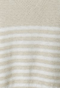 Beżowa i biała poziomo pasowana dzianina z teksturowanym wzorem stępu.