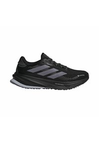 Black running shoes with Gore-Tex upper, featuring dark gray accents and three stripes. Thick sole with textured tread for traction.