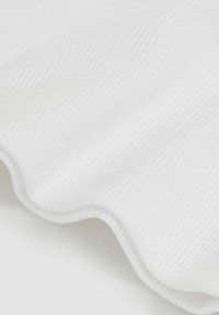 Weißer gerippter Stoff, der eine weiche Textur mit gewellten Kanten zeigt, mit subtilen horizontalen Linien und einem glatten Finish.