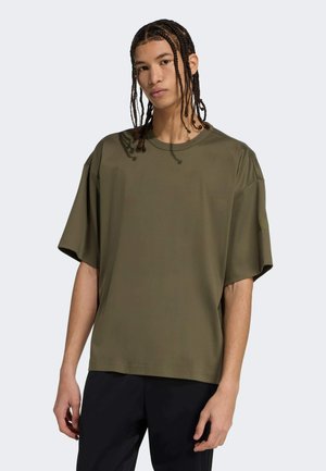 Olivenfarvet oversized t-shirt i glat stof med rund halsudskæring og korteærmer, med en diskret logodetalje på skulderen.