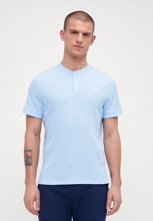Lichtblauw poloshirt met korte mouwen van een gestructureerde stof, met een knoopsluiting met drie knopen en het "POLO" logo op de linkerborst.