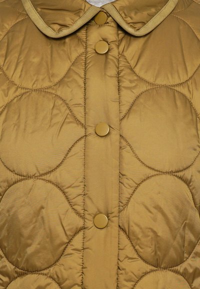 Puffed jaka brūnā siltā krāsā ar noapaļotu apkakli, ar lieliem apļveida rakstiem un zelta toņa spiedpogu aizdari priekša.