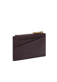 Bordowy skórzany etui na karty o gładkiej fakturze, wyposażony w zamek błyskawiczny i wiele przegródek na karty. Na przodzie tłoczone logo.