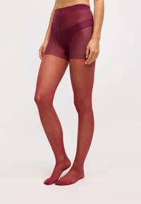 Ciorapi modelați în burgundy, cu un finisaj transparent, design cu puncte și o siluetă cu talie înaltă, dotată cu un elastic neted.