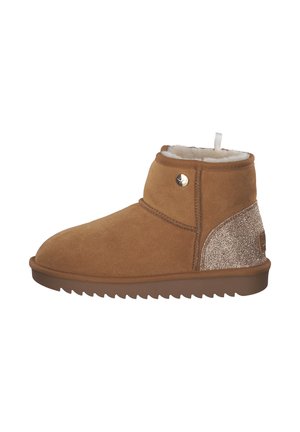 Stivaletto alla caviglia in suede beige con una morbida fodera bianca, suola in brown texturizzato e un accento oro scintillante sul tacco. Punta rotonda e bottone laterale.
