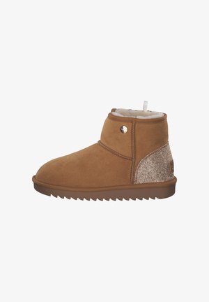 Beige Wildleder-Ankle-Boot mit einer kuscheligen weißen Fütterung, strukturiertem braunem outsole und einem schimmernden goldenen Akzent an der Ferse. Runde Zehenpartie und seitlicher Knopf.