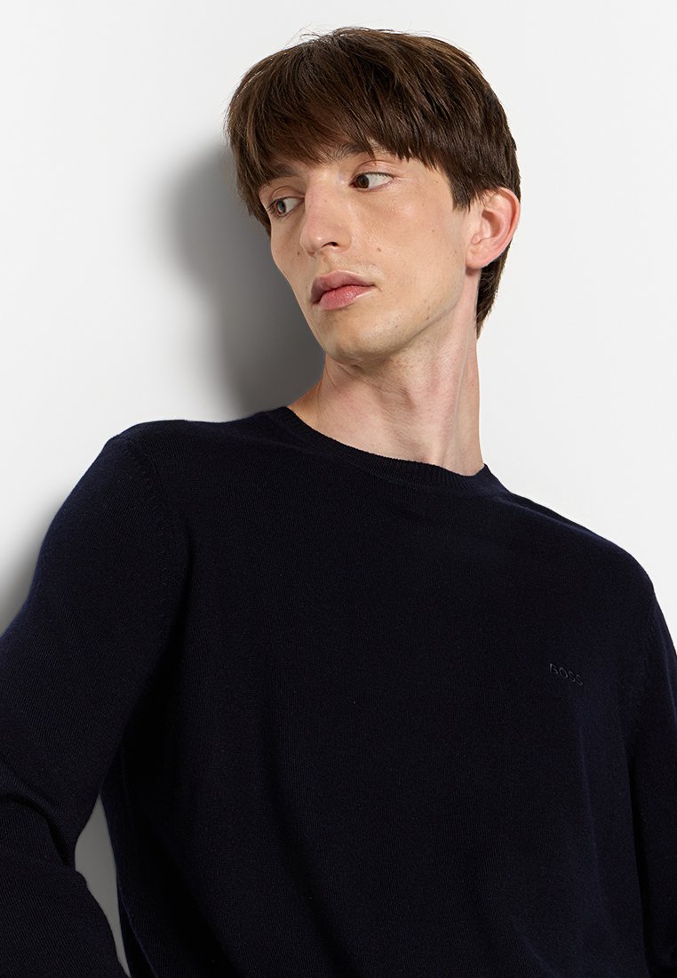 Navyblauwe crewneck trui van een zachte wolmix. Heeft lange mouwen en een subtiele logo-detail op de borst.