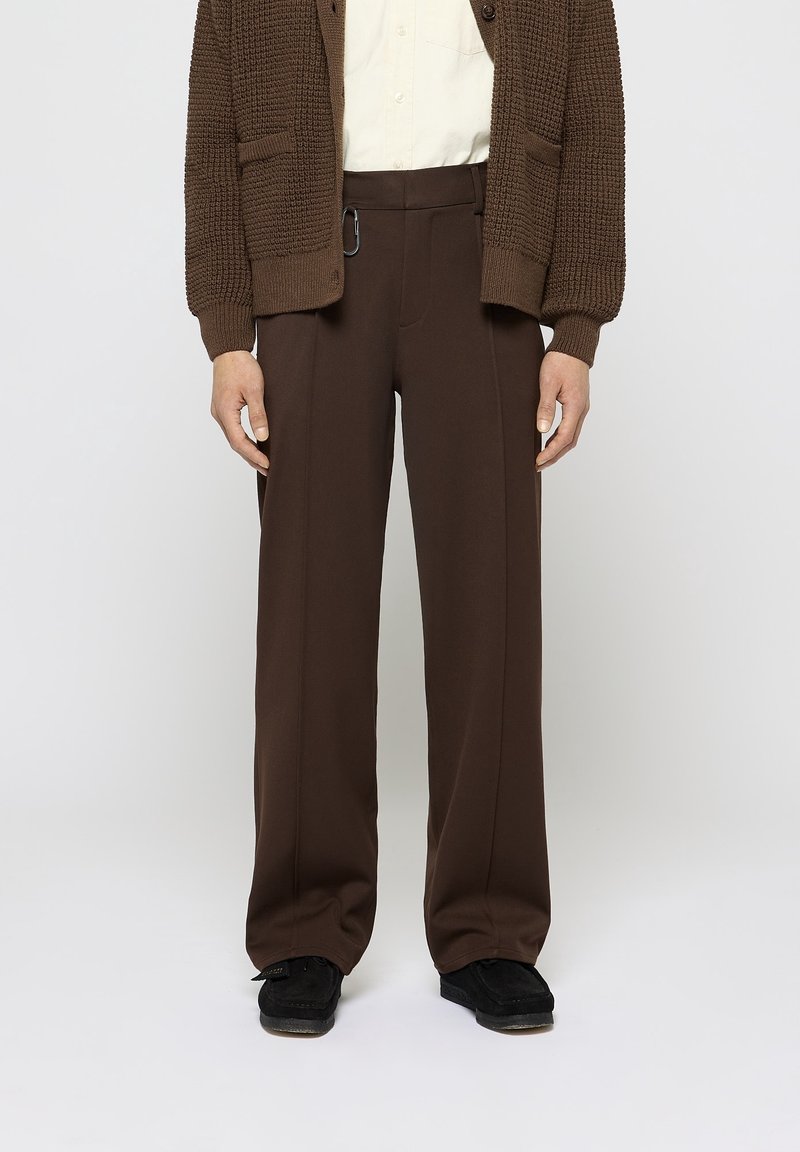 Bruna vida byxor med skräddarsydd passform, med en framsida dragkedja, vertikala sömmar och en utvändig ögla detalj. Styla med en beige skjorta.