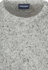 Gray knitted sweater with a ribbed neckline, featuring a speckled texture of lighter and darker fibers throughout. Label reads "SUITABLE."