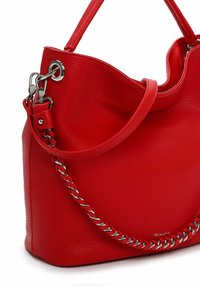 Czerwona skórzana torebka o fakturowanym wykończeniu, z falistym górnym brzegiem, paskiem ozdobionym łańcuszkiem oraz srebrnym logo.
