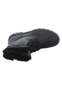 Bottines en cuir noir avec doublure en fausse fourrure, semelle épaisse et fermeture à lacets ; dotées d'un motif en losange sur le côté et d'une construction robuste.