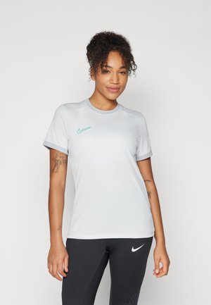 T-shirt atletico Nike grigio chiaro a maniche corte, con logo turchese sul petto, texture liscia e design aderente.