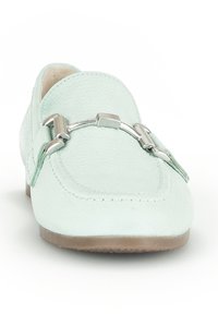 Lichtgroene loafers van gestructureerd suède, met een zilveren metalen accent en een platte, tan rubberen zool. Klassiek ontwerp met gestikte randen.