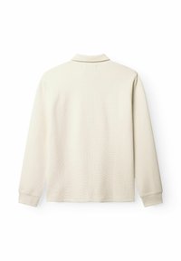 Hosszú ujjú, világos bézs pólóing bordázott textúrával, puha gallérral és elasztikus mandzsettákkal. Háttal látható, minta vagy díszítés nélkül.