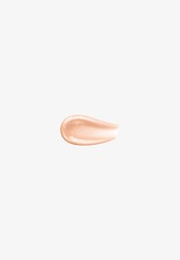 Campione di crema beige scintillante con fini particelle di glitter su uno sfondo grigio chiaro.