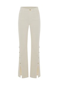 Pantaloni beige a palazzo con vita aderente, tasche frontali e spacchi laterali con bottoni dorati lungo le gambe.