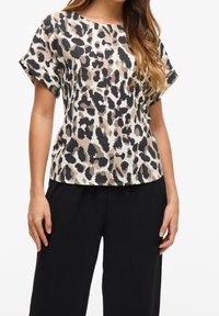 Blus med leopardmönster i beige och svart, kort ärm, rund halsringning, mjukt tyg. Matching med lösa svarta texturerade byxor.