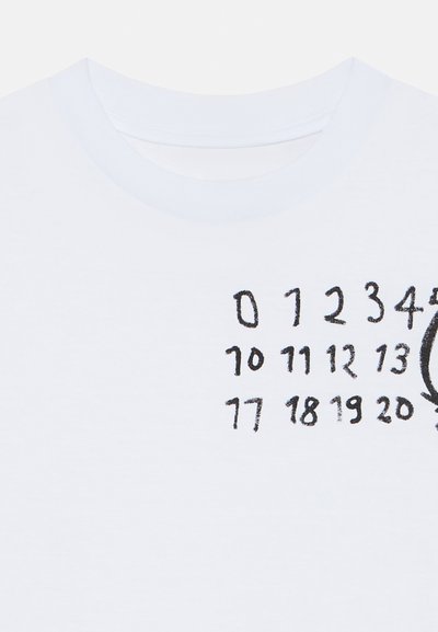 Biała bawełniana koszulka z czarnymi nadrukowanymi cyframi ułożonymi w grupach, z dodatkowym okrągłym detalem graficznym po prawej stronie.
