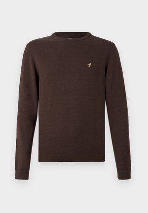 Brūns adīts džemperis ar garām piedurknēm, apaļu kakla izgriezumu un ribotām malām. Uz krūtīm maza zelta putna logo.