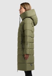 Langer, olivgrüner Puffer-Mantel mit Kapuze, ausgestattet mit einem gesteppten Design, Reißverschluss-Seitentasche und logoakzentuierter Saum.