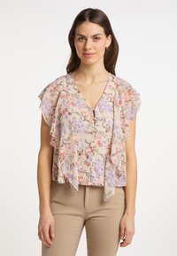 Blusa floreale con scollo a V, maniche arricciate e bottoni. Il motivo include fiori rosa e viola su uno sfondo beige.