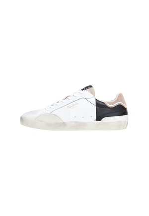 Zapatilla blanca que presenta una mezcla de materiales de cuero y textil, con acentos en negro y beige, puntera redonda y suela de goma texturizada.