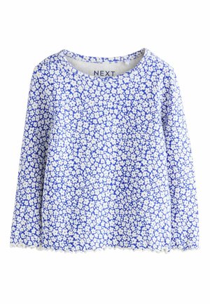 Pikkade varrukatega pluus ümarate kaelustega. Kahel taustal on sinine taust väikeste valgete lillemustritega. Alumine serv on laineline.