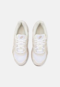 Vita mesh och mockaskor med beige accenter, med en rund tå, snörning och texturerade detaljer på sulan.