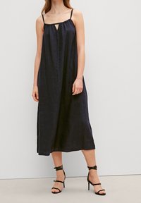 Laivastonsininen pellavaisesta valmistettu midi-mekko, jossa on olkaimet, avonainen yksityiskohta kaula-aukossa ja rento istuvuus. Yhdistetty mustiin remmillisiin korkokenkiin.