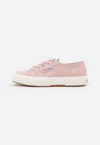 Baskets basses en toile rose clair avec semelle en caoutchouc blanche et lacets, avec une petite étiquette logo Superga sur le côté.