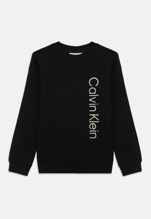 Black sweatshirt made of cotton, featuring a ribbed crew neck and cuffs. "Calvin Klein" logo printed vertically in beige on the front.