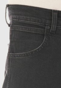 Jeans de mezclilla negra con una textura suave, que cuentan con un bolsillo frontal, costuras en contraste y un cierre de botón seguro en la cintura.