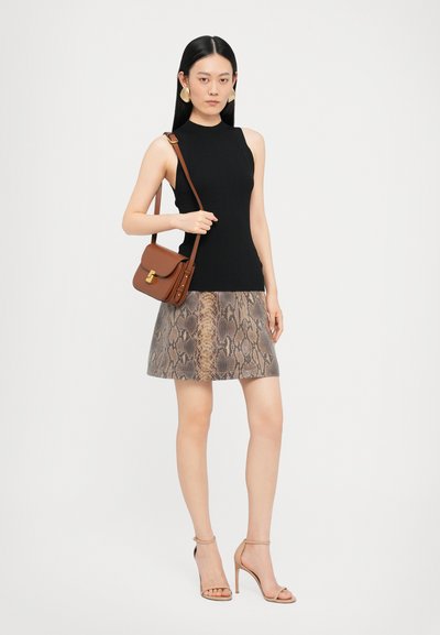 Top fără mâneci, cu model în dungi negre, fustă bej cu imprimeu de șarpe, geantă maro tip crossbody cu detalii aurii și sandale cu toc în nuanță nude, cu bretele. Texturi netede.
