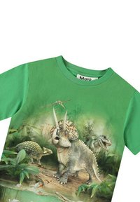 Grøn bomulds t-shirt med et dinosaurmotiv, der viser en triceratops, stegosaurus og en T-rex i en frodig junglescene.