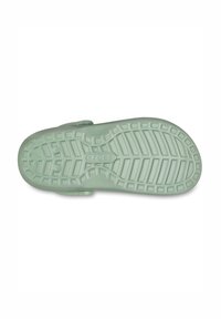 Light green Crocs sole with a textured surface, featuring a pattern of ridges and circular grips for traction. "Crocs" logo centered.
