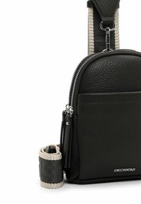 Černá kožená crossbody taška s texturovaným povrchem, vybavená stříbrným zipem, přední kapsou a odnímatelným textilním popruhem v černobéžové barvě.
